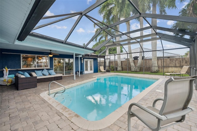 view of pool featuring a patio area, ceiling fan, a lanai, and an outdoor living space