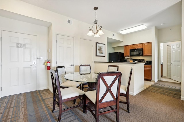 dining space featuring an inviting chandelier and dark colored carpet