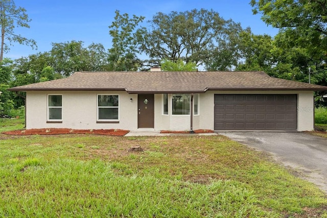 ranch-style house featuring a front lawn and a garage