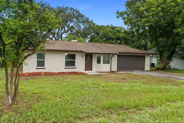 single story home featuring a garage and a front lawn