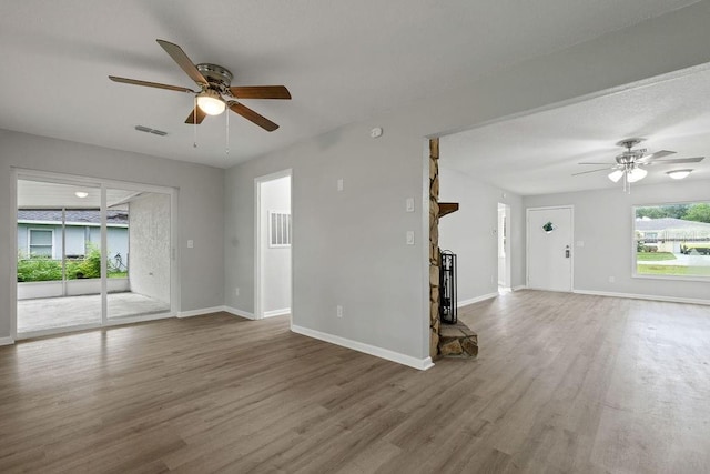 unfurnished living room featuring ceiling fan and hardwood / wood-style flooring