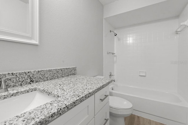 full bathroom featuring vanity, toilet, hardwood / wood-style floors, and tiled shower / bath