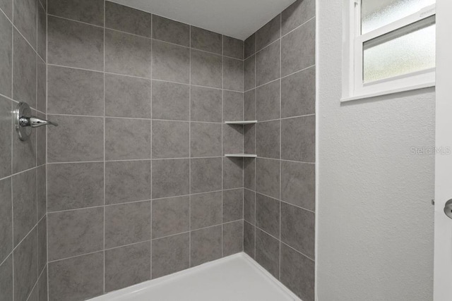 bathroom with a tile shower