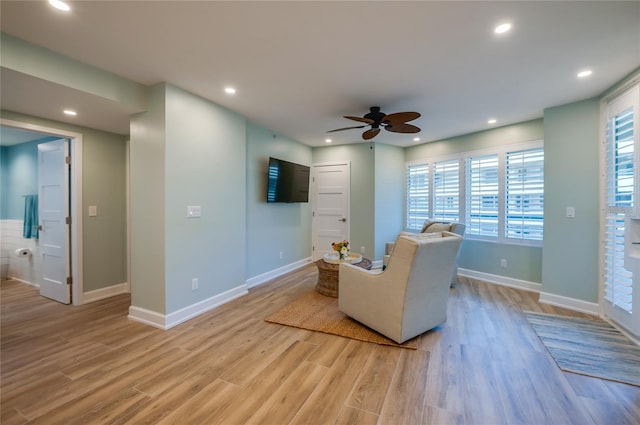 living area featuring light wood-type flooring, ceiling fan, and plenty of natural light