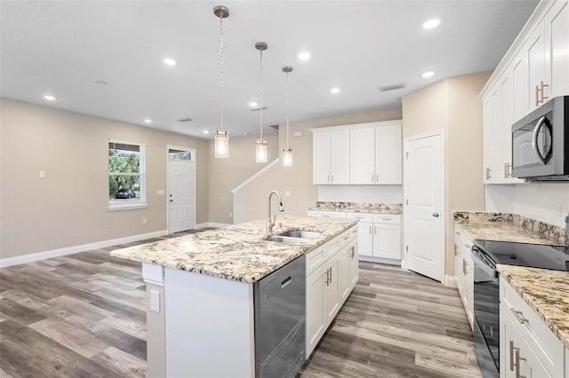 kitchen with a kitchen island with sink, appliances with stainless steel finishes, white cabinetry, and sink