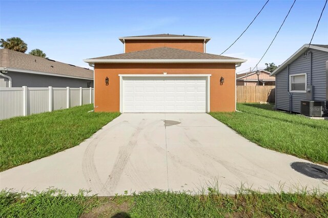 view of front of house featuring a garage, central AC, and a front yard