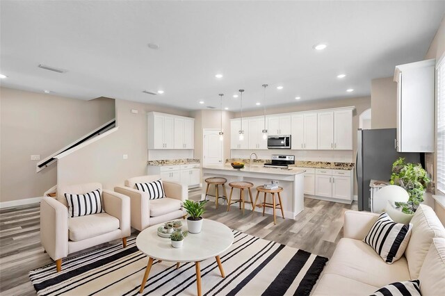 living room with light hardwood / wood-style flooring and sink