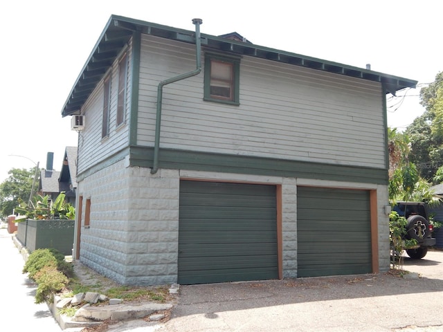 view of property exterior with a garage and fence