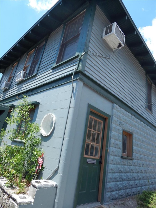 view of side of home featuring an AC wall unit