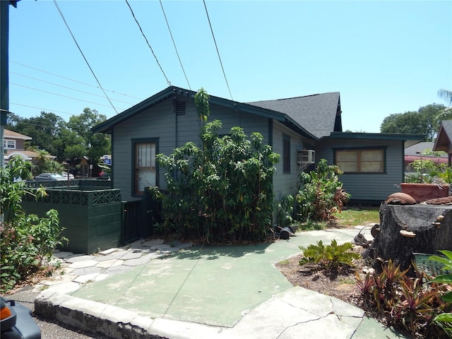 view of front of house featuring a patio area and roof with shingles