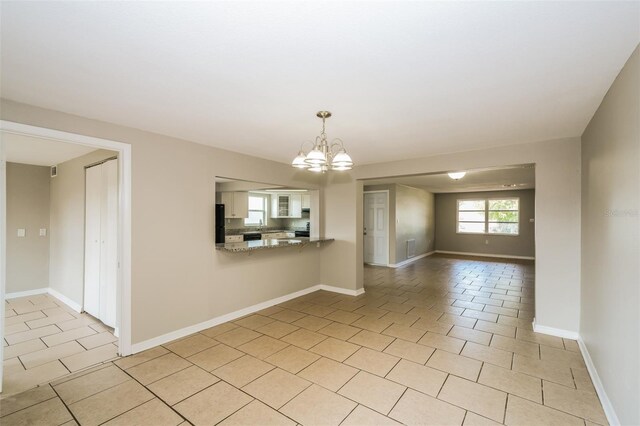 tiled empty room with a chandelier