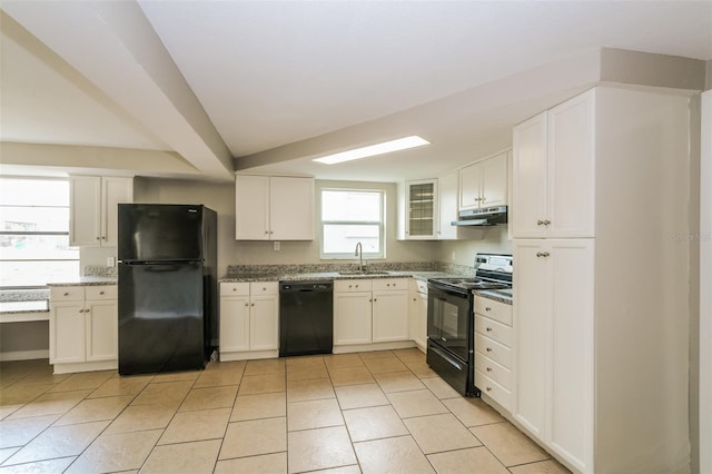 kitchen with black appliances, light stone countertops, under cabinet range hood, white cabinetry, and a sink