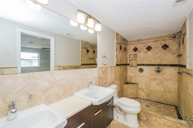 bathroom with tile walls, toilet, a tile shower, and backsplash