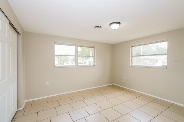 empty room featuring visible vents, baseboards, and a healthy amount of sunlight