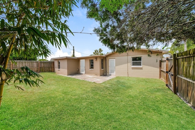 back of property with a yard, a fenced backyard, and a patio area