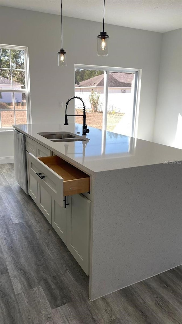 kitchen featuring white cabinets, pendant lighting, dark hardwood / wood-style floors, and a kitchen island with sink