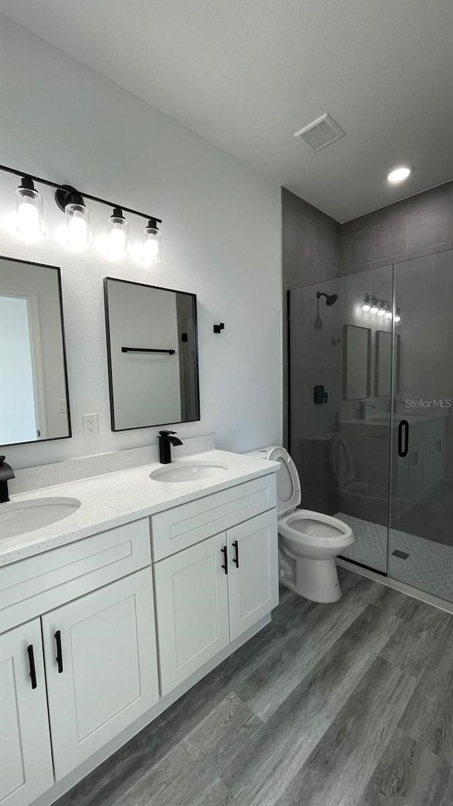 bathroom featuring wood-type flooring, vanity, and a shower with door