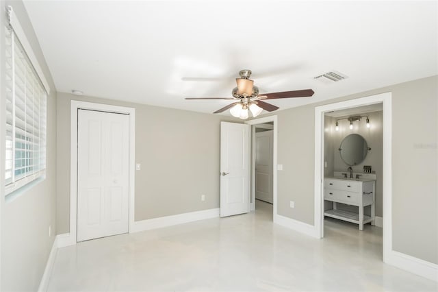 unfurnished bedroom with ensuite bathroom, sink, ceiling fan, and a closet