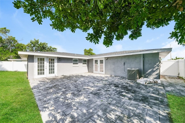 view of front facade featuring french doors, a front lawn, a patio, and central air condition unit