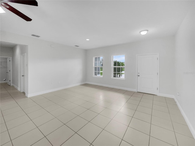 empty room featuring visible vents, ceiling fan, baseboards, and light tile patterned flooring