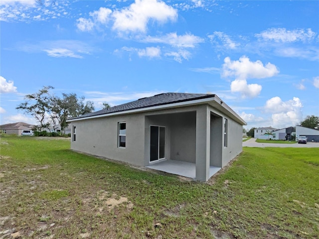 rear view of property featuring a lawn and a patio