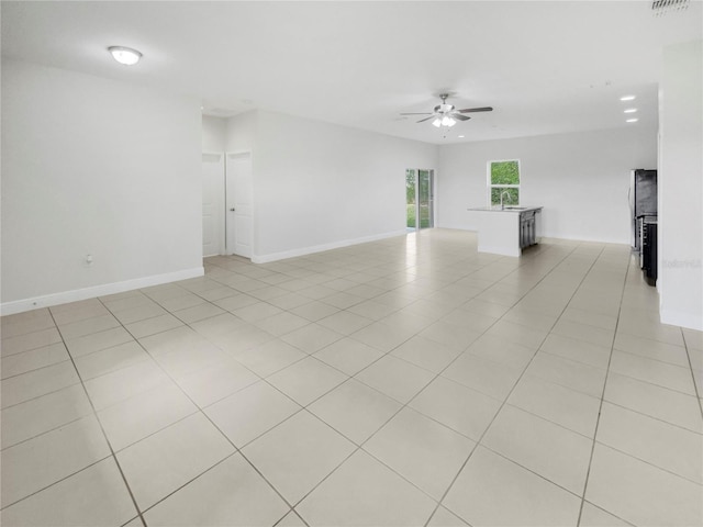 tiled spare room featuring sink and ceiling fan