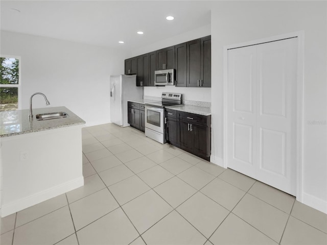 kitchen featuring light tile patterned floors, stainless steel appliances, sink, and light stone countertops