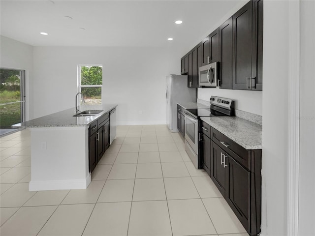 kitchen featuring sink, light stone countertops, appliances with stainless steel finishes, and light tile patterned flooring