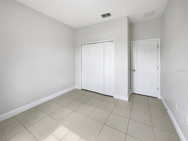 unfurnished bedroom featuring light tile patterned floors and a closet