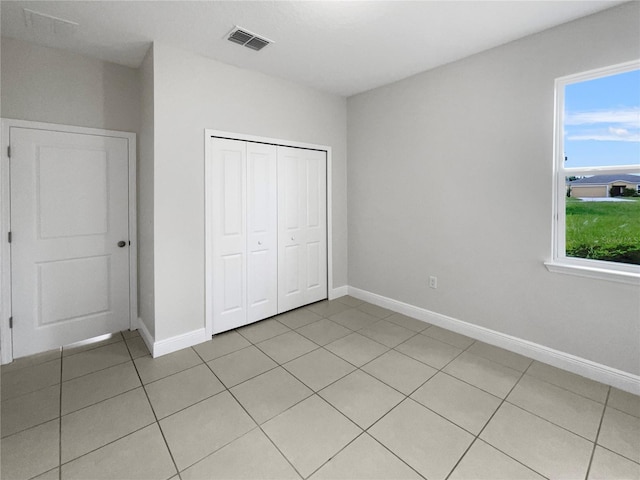 unfurnished bedroom with a closet and light tile patterned flooring