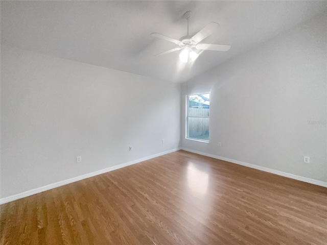 spare room with ceiling fan, vaulted ceiling, and hardwood / wood-style flooring