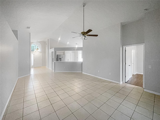 unfurnished living room with high vaulted ceiling, ceiling fan, light tile patterned floors, and a textured ceiling