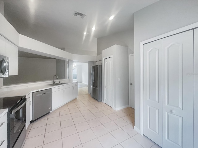 kitchen featuring appliances with stainless steel finishes, light tile patterned flooring, sink, and white cabinets