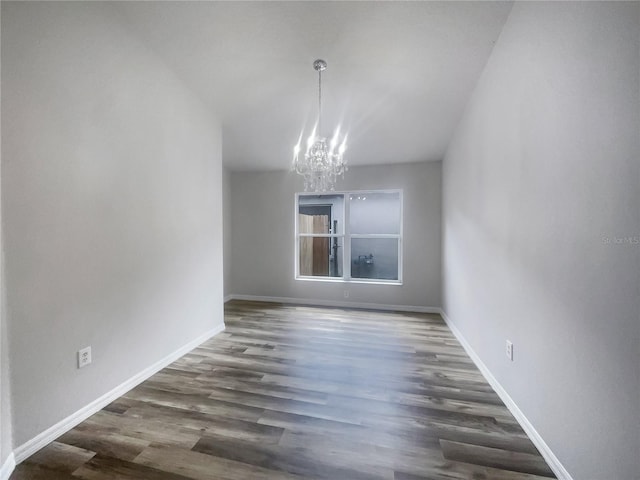 unfurnished dining area featuring dark wood-type flooring and a notable chandelier