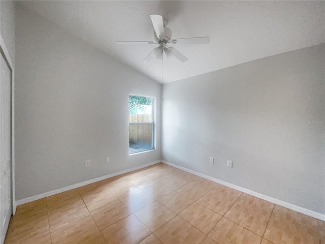 spare room featuring vaulted ceiling, light tile patterned floors, and ceiling fan