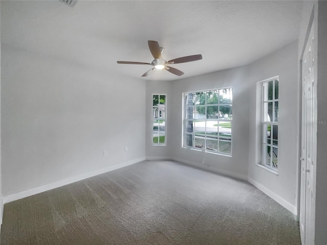 empty room featuring ceiling fan and carpet