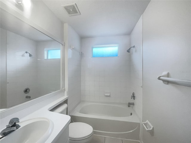 full bathroom featuring a healthy amount of sunlight, toilet, tiled shower / bath combo, and vanity