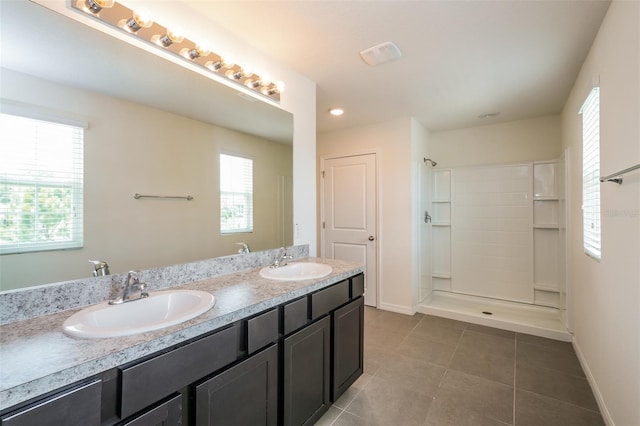 bathroom with tile patterned flooring, vanity, and walk in shower