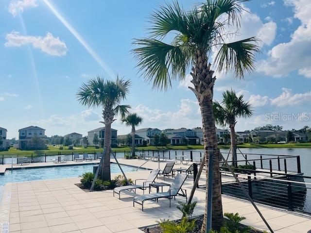 exterior space with a water view and a community pool