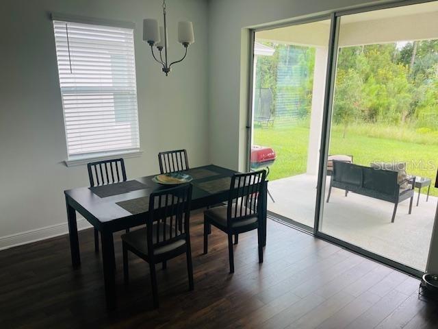 dining area with an inviting chandelier and dark hardwood / wood-style flooring