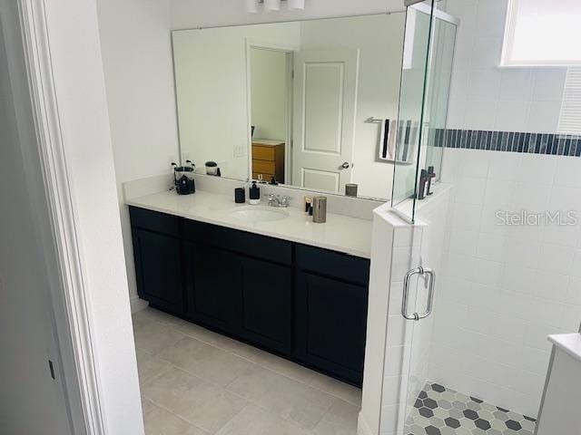 bathroom with tile patterned flooring, vanity, and an enclosed shower