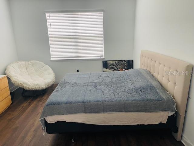 bedroom featuring dark hardwood / wood-style floors and multiple windows