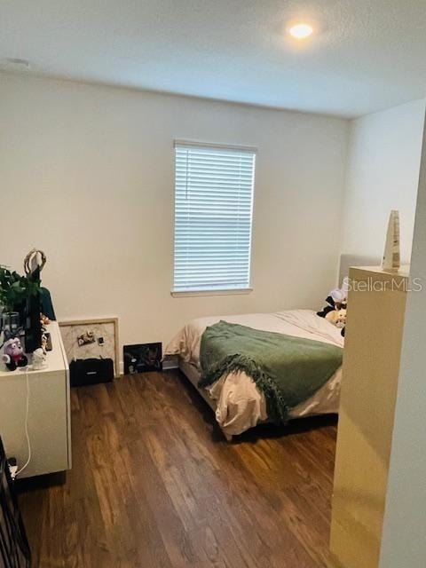 bedroom with dark hardwood / wood-style floors