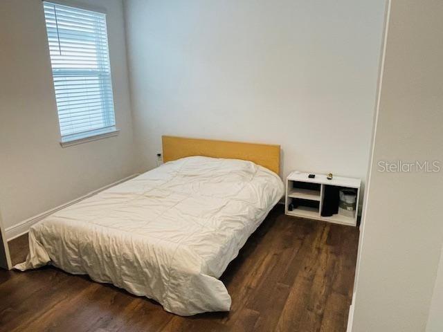 bedroom with dark hardwood / wood-style flooring