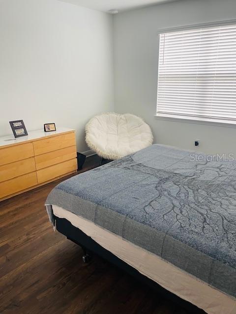 bedroom with dark hardwood / wood-style flooring