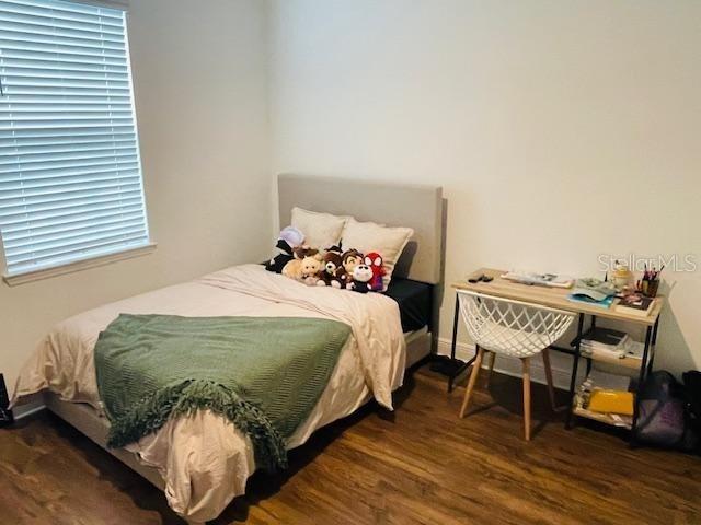 bedroom with dark hardwood / wood-style floors