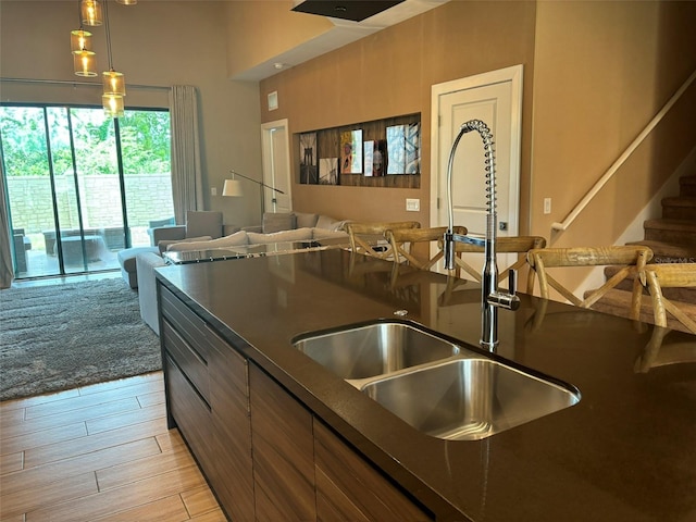 kitchen with hanging light fixtures, sink, and light hardwood / wood-style floors