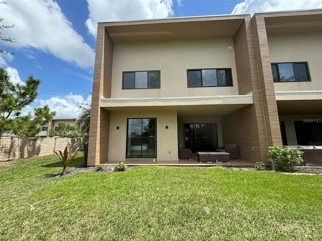 rear view of house with a lawn and a patio