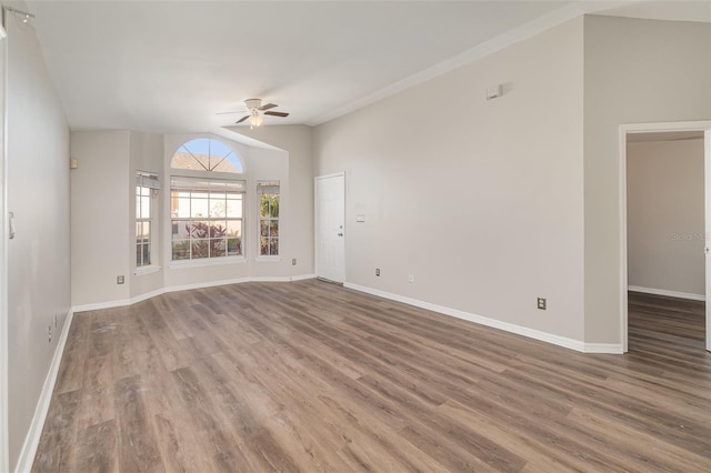 empty room featuring ceiling fan, wood finished floors, lofted ceiling, and baseboards