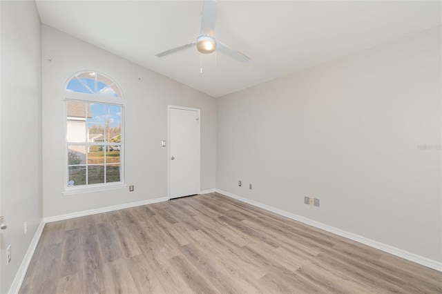 spare room with light wood-type flooring, ceiling fan, lofted ceiling, and baseboards